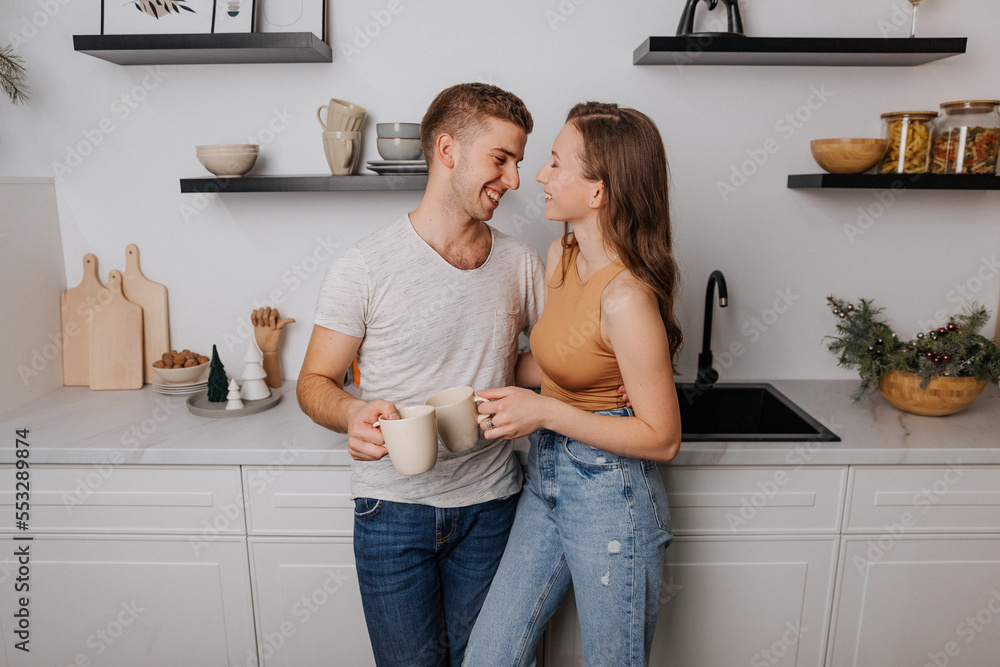 Loving young couple hugging in the kitchen Loving young couple hugging in the kitchen