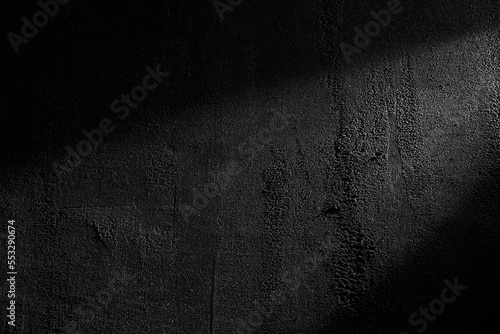 Black wall rough texture background, concrete floor or old grunge backdrop, illuminated by sun ray. Close up of dark graphite surface for modern background design. Concept of textures and background. photo