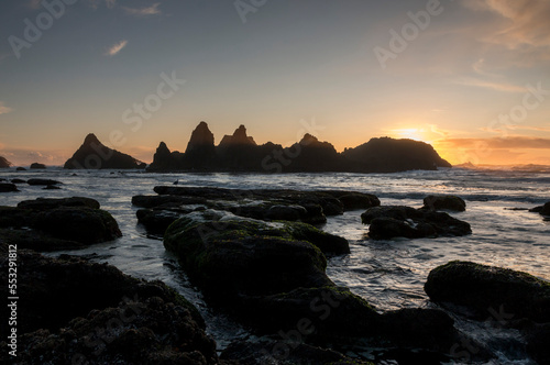 sunset over the beach with rugged rocky islets , Little Creek Scenic Overlook, Oregon, US