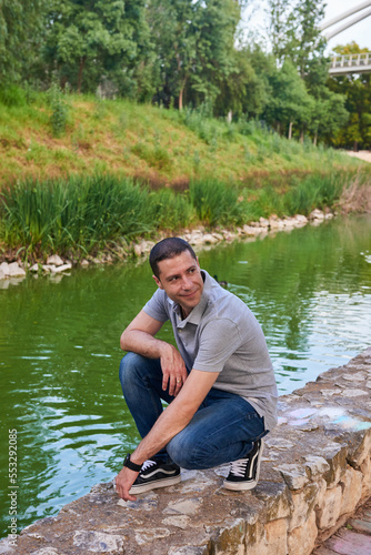 A young boy sitting on the banks of a canal