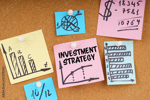 On the board are stickers with graphs and diagrams and the inscription - Investment Strategy