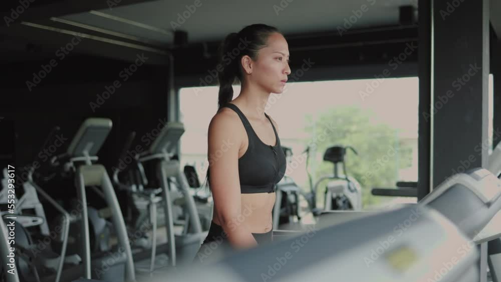 Woman having workout on treadmill at gym side view Woman having workout on treadmill at gym side view