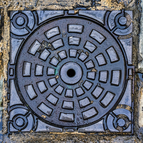A wet manhole cover in the street