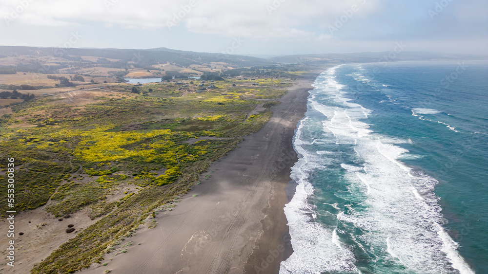 Aerial shot of a beach and the pacific ocean at Pichilemu, Chile