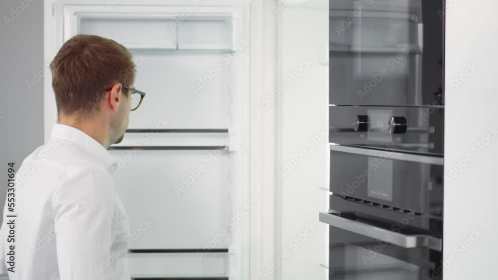 Young man open empty fridge. Hungry guy look into empty refrigerator with no food. Realtime Young man open empty fridge. Hungry guy look into empty refrigerator with no food. Realtime