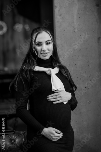 Beautiful young pregnant woman in black dress