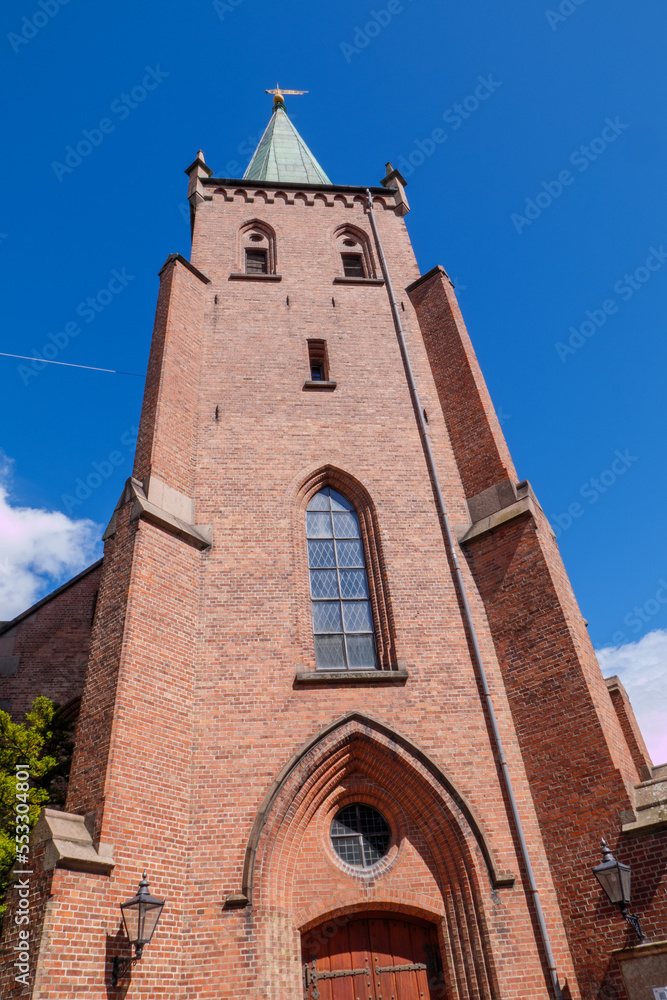 Kirchturm der Østre Aker kirke. Østre Aker Kirche ist eine Pfarrkirche im nordöstlichen Teil von Oslo, Norwegen. Das Kirchengebäude von 1860 im neugotischen Stil hat Außenwände aus Backstein