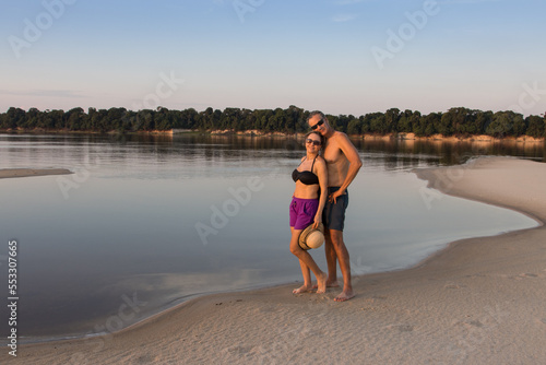 Couple at the Rio Negro in the Amazon of Brazil enjoying themselves late in the day