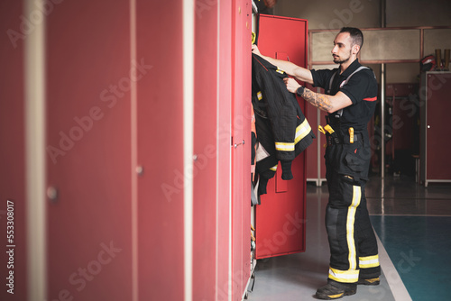 Konstfotografi A young firefighter picking up his uniform at the locker room of the fire station