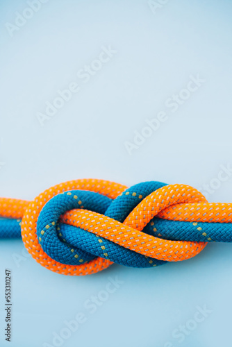 Eight knot on a rope on a blue background close up