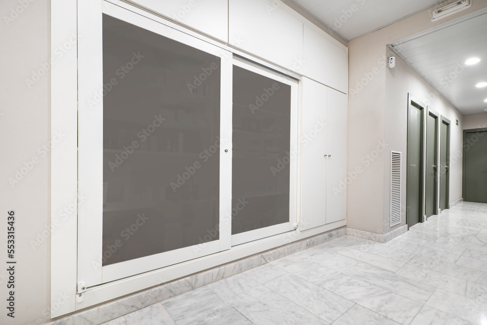 Sliding glass door wardrobe with white wood and marble floors Sliding glass door wardrobe with white wood and marble floors