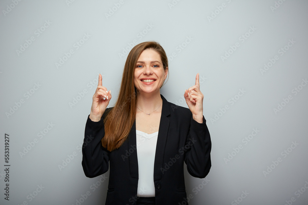 Smiling business woman in black suit pointing two fingers up isolated portrait. Smiling business woman in black suit pointing two fingers up isolated portrait.