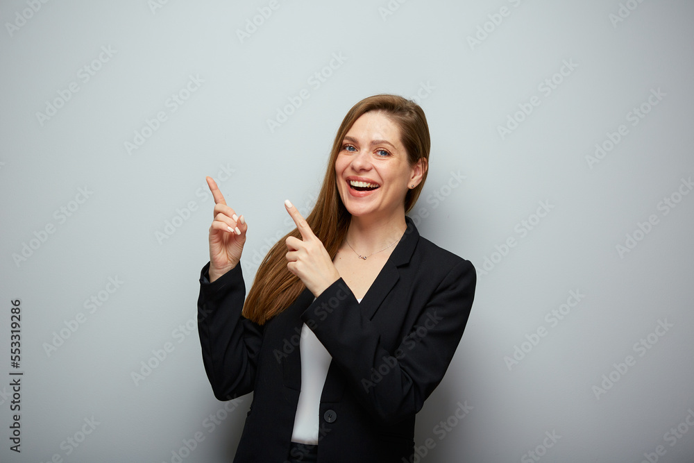 Smiling business woman in black suit pointing two fingers up isolated portrait. Smiling business woman in black suit pointing two fingers up isolated portrait.