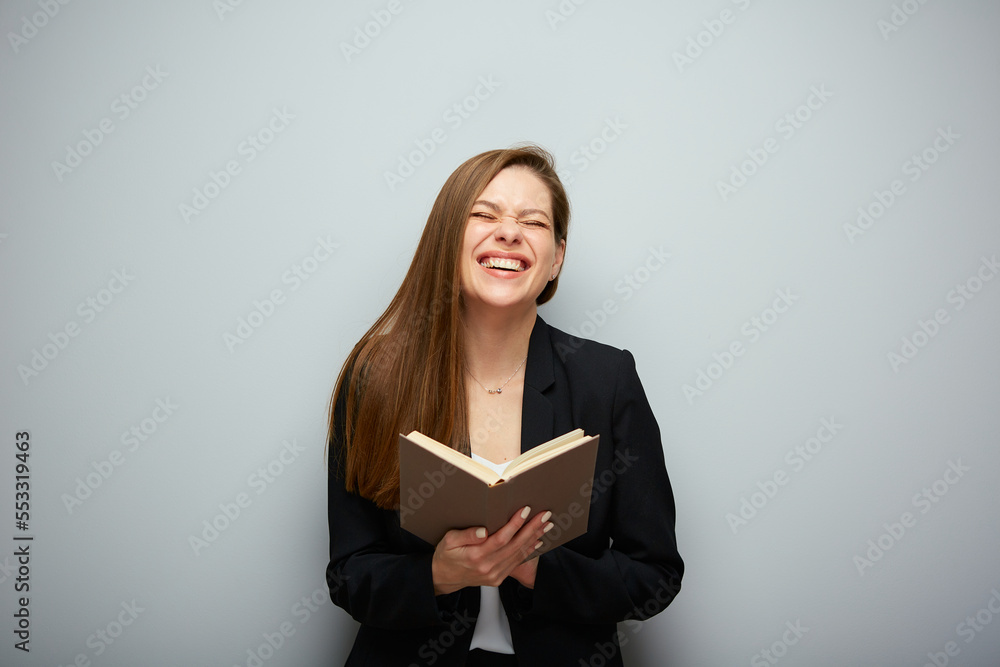 Laughing woman teacher holding book. Isolated portrait with copy space. Laughing woman teacher holding book. Isolated portrait with copy space.