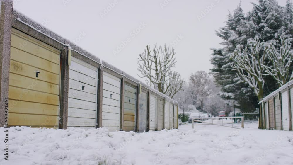 Camera pans across snow covered residential garages