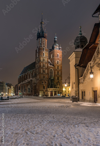 St Mary's church on snow covered Main Square in winter Krakow, illuminated in the night © tomeyk