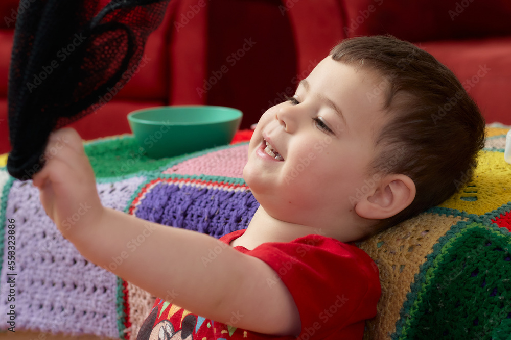 cute boy playing with toys and watching cartoons cute boy playing with toys and watching cartoons