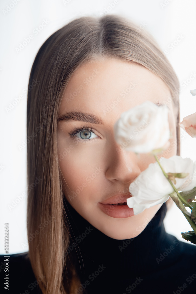 Concept beauty care skin face in salon. Portrait Caucasian Fashion of beautiful young woman green eyes with bouquet of white flowers Concept beauty care skin face in salon. Portrait Caucasian Fashion of beautiful young woman green eyes with bouquet of white flowers