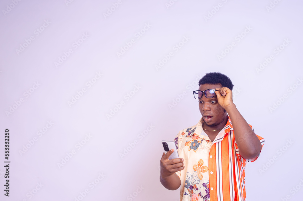Cheerful African American man in white shirt using mobile phone application. Cheerful African American man in white shirt using mobile phone application.