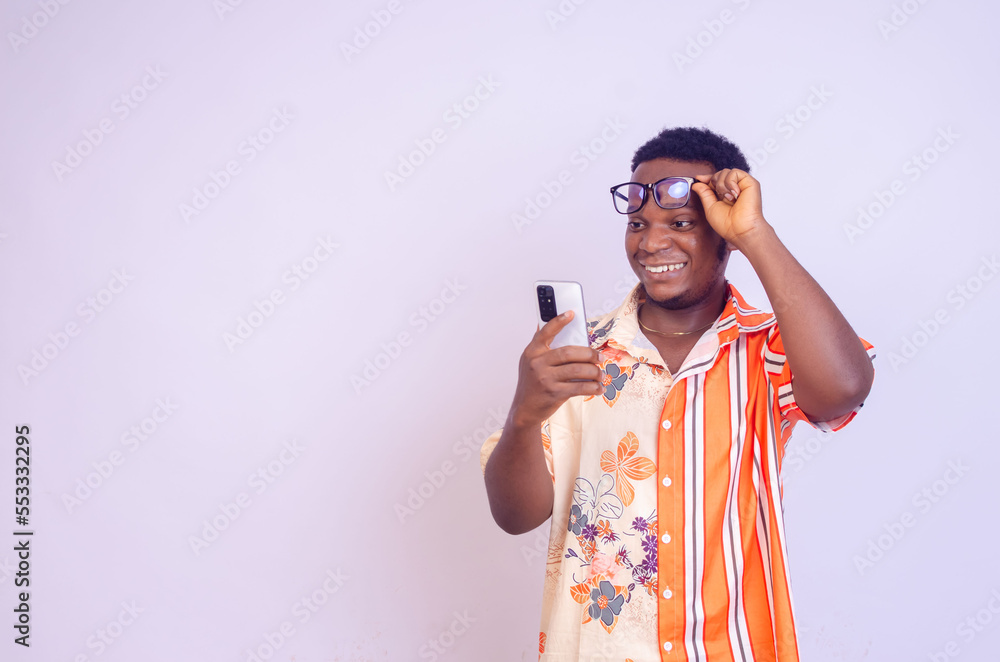 Cheerful African American man in white shirt using mobile phone application. Cheerful African American man in white shirt using mobile phone application.