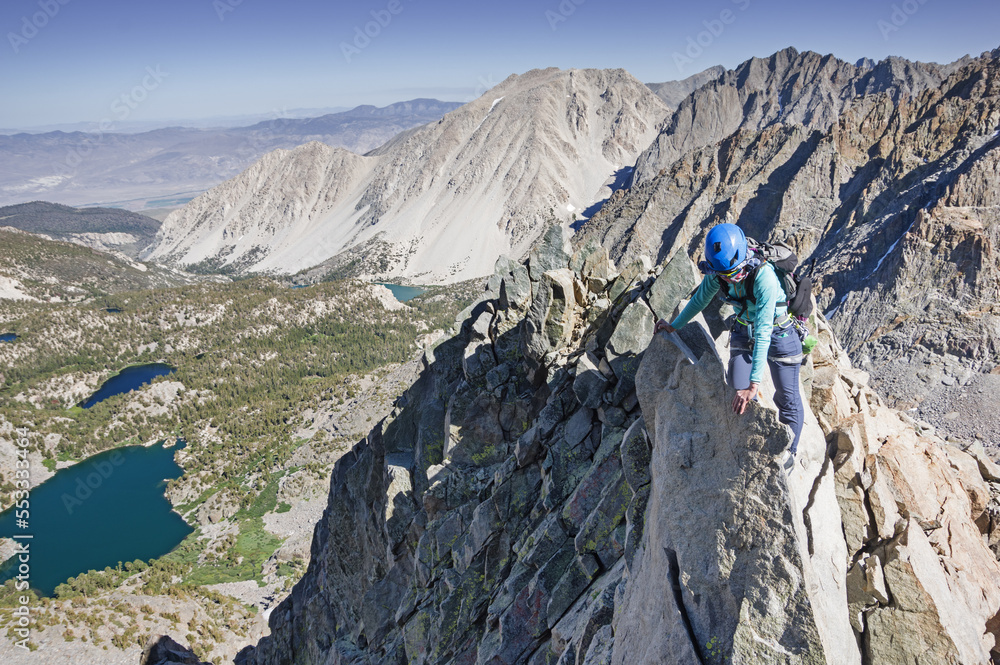 Woman Climbing Up Mountain Ridge