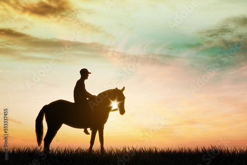 Silhouette of young man riding a horse on meadow