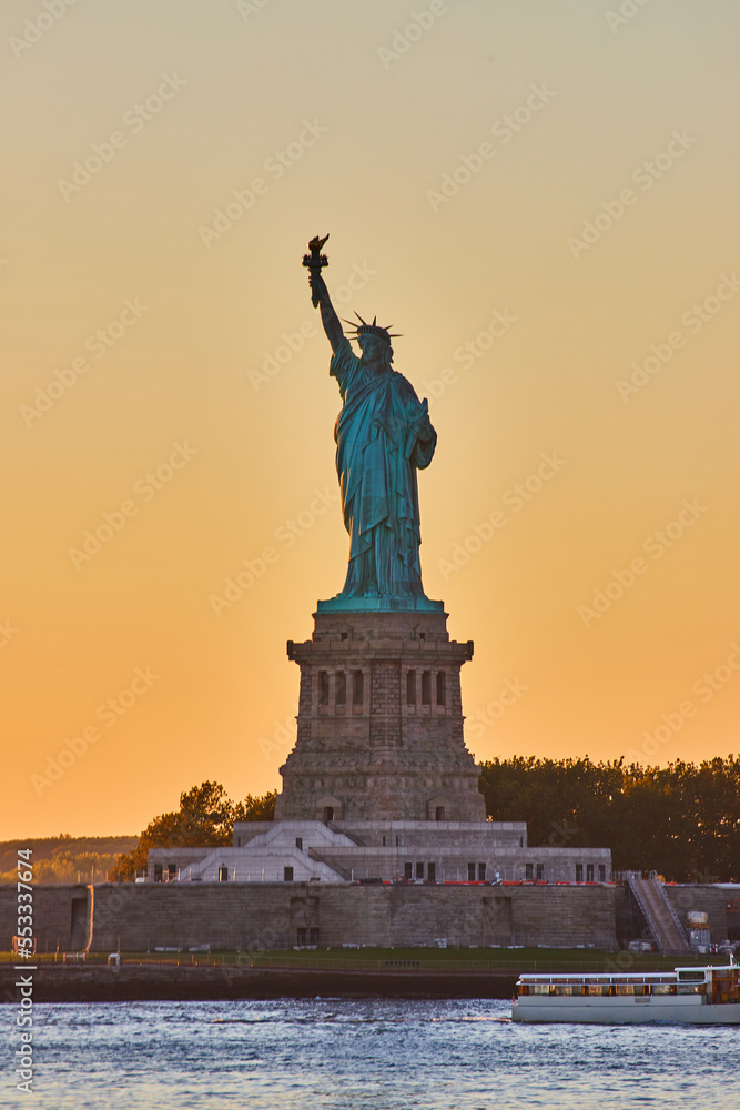 New York City golden hour light around iconic Statue of Liberty in dusk New York City golden hour light around iconic Statue of Liberty in dusk