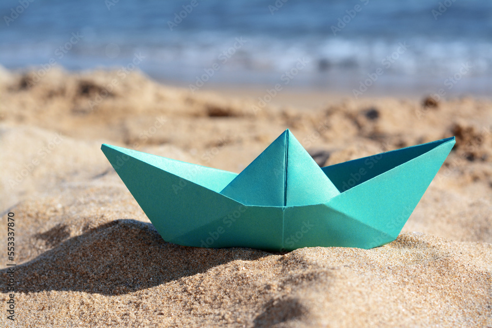 Green paper boat near sea on sunny day, closeup Green paper boat near sea on sunny day, closeup
