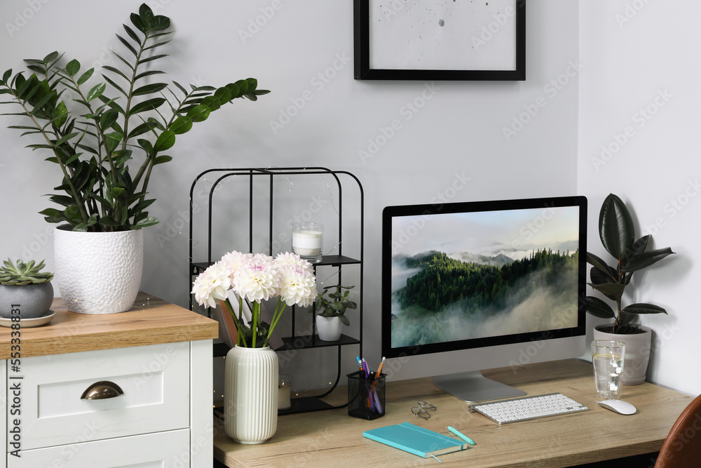 Fototapeta premium Comfortable workplace with modern computer, decor and office supplies on wooden table indoors