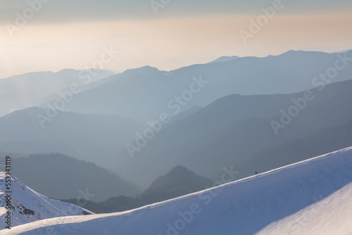 Mountaineer on the line of snow-capped mountains and evening western sky