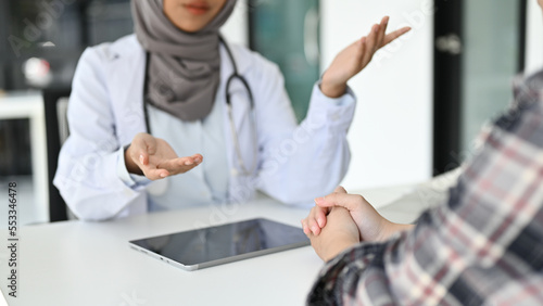 Canvas Print cropped image, A professional Asian Muslim female doctor talking with a patient