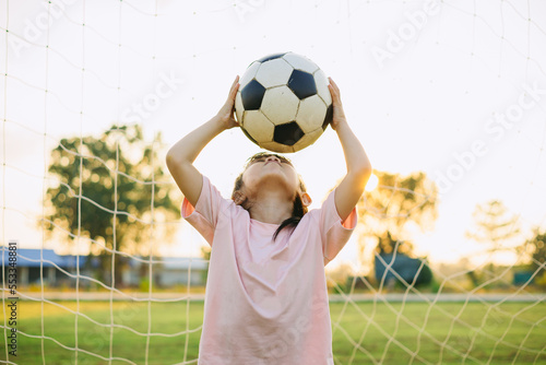 kids are playing soccer football for exercise under the sunlight. Children activity outdoor for good health.