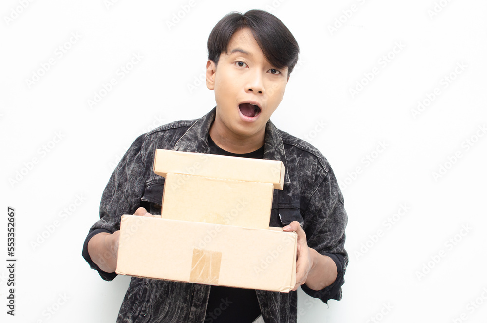 Happy Ecstatic Young Asian man Holding Package Parcel box isolated over white background. Delivery courier and shipping service concept Happy Ecstatic Young Asian man Holding Package Parcel box isolated over white background. Delivery courier and shipping service concept
