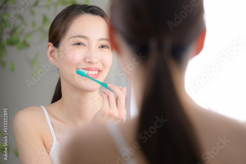笑顔で歯ブラシをする美しい女性 photo