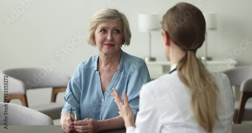 Wallpaper Mural Mature woman listens to female therapist at visit in public hospital, clinic patient laughing while receive consultation looks optimistic feel happy. Eldercare, medicine, professional medical services Torontodigital.ca
