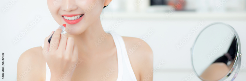 Beautiful young asian woman applying lipstick red on mouth, beauty girl looking facial at mirror for makeup cosmetic with lips elegance, make up with sexy of female, skin care and health concept. Beautiful young asian woman applying lipstick red on mouth, beauty girl looking facial at mirror for makeup cosmetic with lips elegance, make up with sexy of female, skin care and health concept.