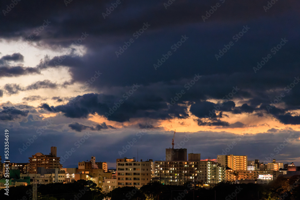 Dramatic storm clouds over apartments and office buildings at sunset
