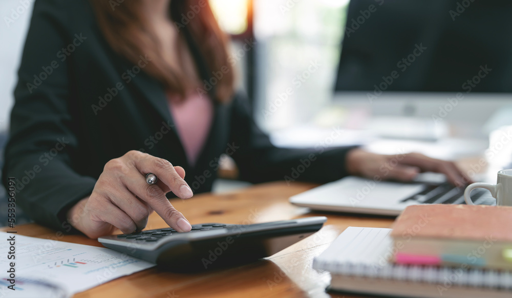 Business woman hand using calculator to calculate the company's financial results and budget. Business woman hand using calculator to calculate the company's financial results and budget.
