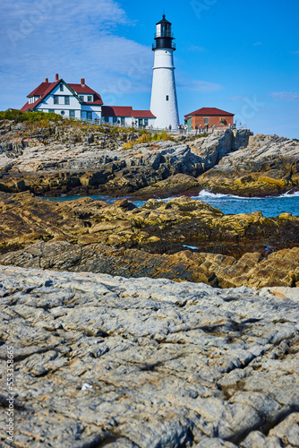 Huge rocky coastline in detail with overlooking white lighthouse