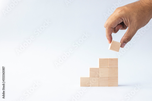 hand arranged stacked wooden cubes as steps on white background. concept about education, business, play, strategy, and success.