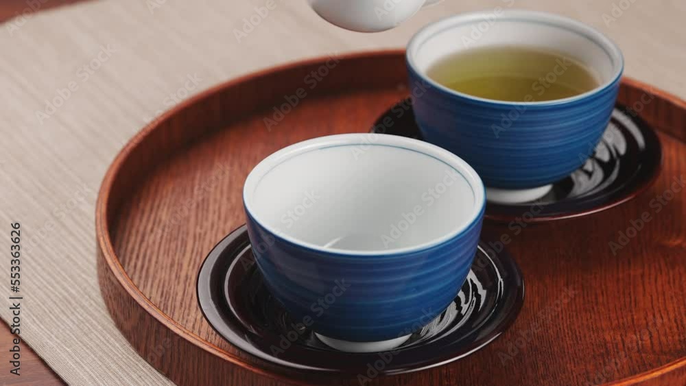 急須で湯呑に熱い緑茶を淹れる 急須で湯呑に熱い緑茶を淹れる