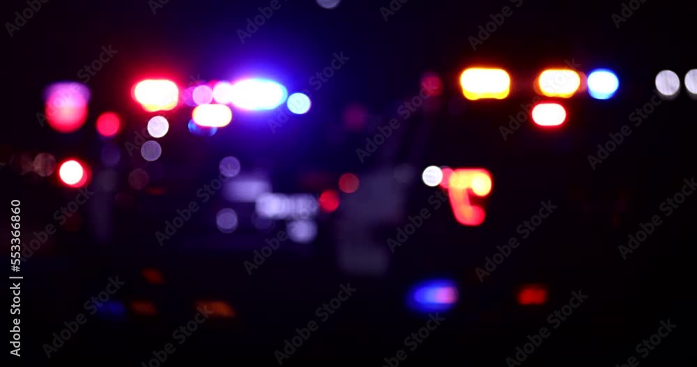 Abstracted night time bokeh view of police units responding to the scene of an emergency.