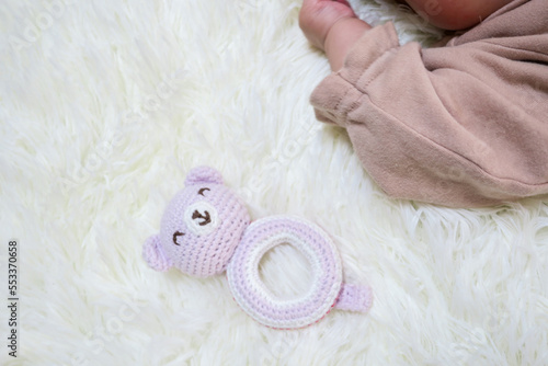 赤ちゃんの手とピンクのクマのおもちゃ