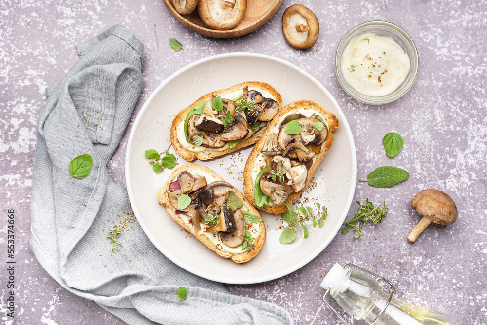 Plate of tasty toasts mushrooms and bowl of sauce on grunge background
