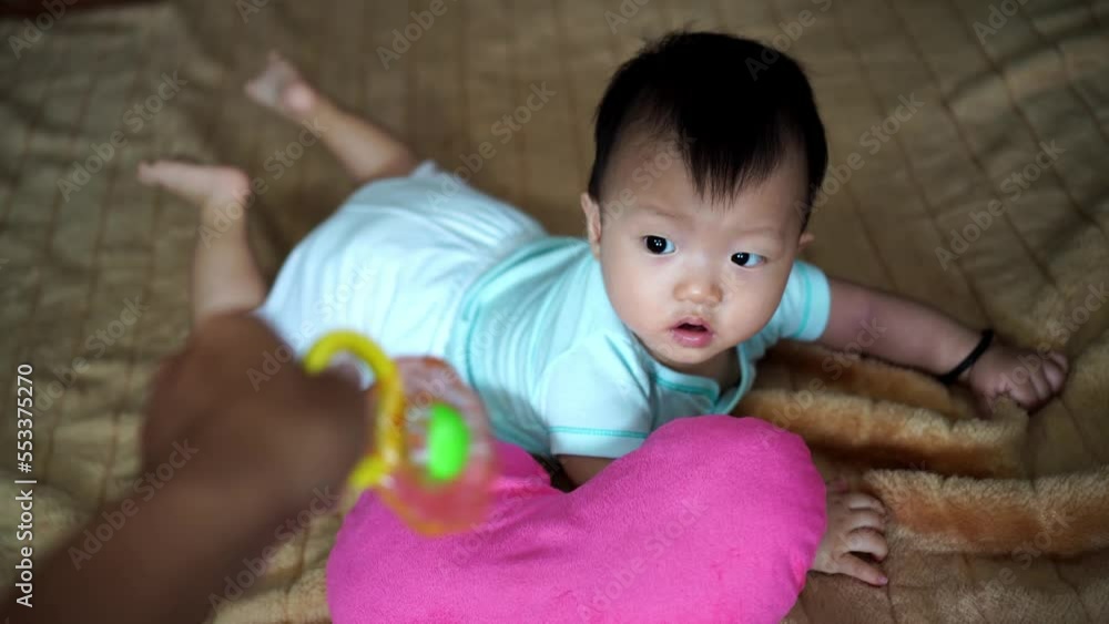 Father hand hold the rattle toy to attract baby boy Father hand hold the rattle toy to attract baby boy