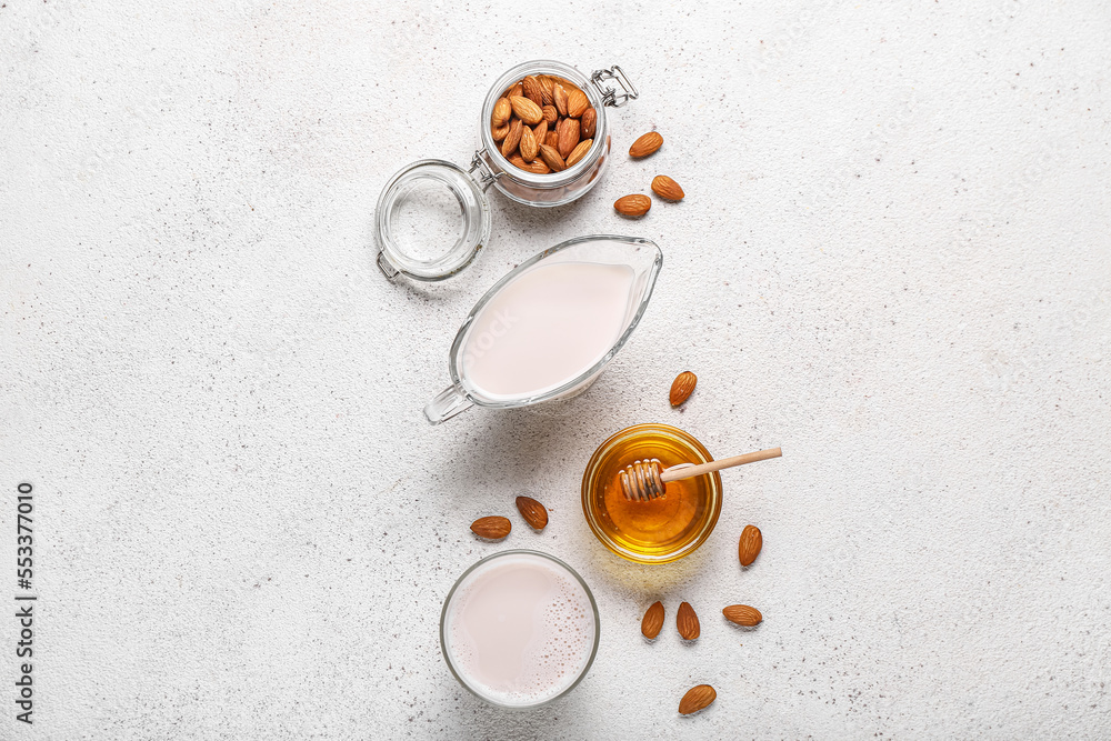Composition with healthy almond milk, nuts and honey on light background Composition with healthy almond milk, nuts and honey on light background