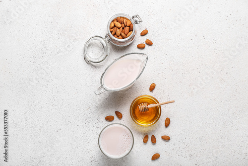 Composition with healthy almond milk, nuts and honey on light background