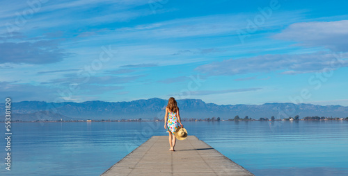 Woman walking on wooden pier ( Catalonia,  Delta del Ebro,  Spain)