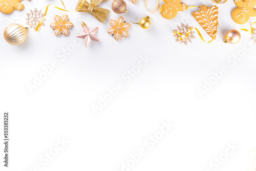 Christmas Gingerbread cookie background. Various festive biscuits - Gingerbread man, snowflakes, Christmas tree - with Xmas, New Year, Noel golden decoration on light colored background top view