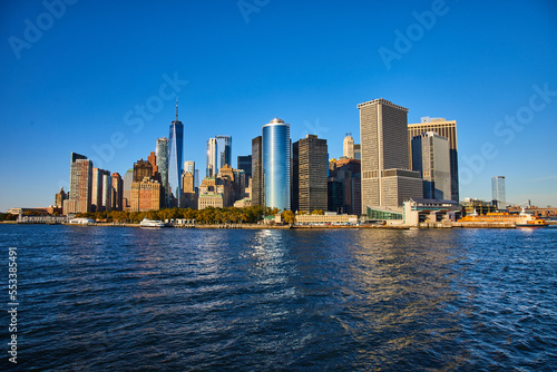 Beautiful New York City skyline from the water with sunlight hitting southern Manhattan